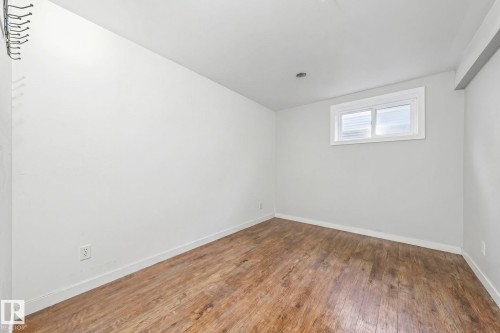 This room features wood-look flooring, light-colored walls, and a window providing natural light - 115 Warwick Road, Edmonton, AB - Indoor Photo Showing Other Room