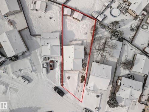 Aerial view of the property, outlined in red, featuring a main residence with a gabled roof and a detached structure - 115 Warwick Road, Edmonton, AB - Other
