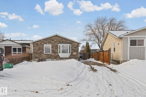 The property features a stone exterior facade, a bay window, and a paved driveway - 115 Warwick Road, Edmonton, AB - Outdoor