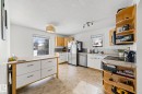Bright kitchen featuring white walls, a light-toned ceiling, and neutral flooring - 115 Warwick Road, Edmonton, AB  - Indoor Photo Showing Kitchen 