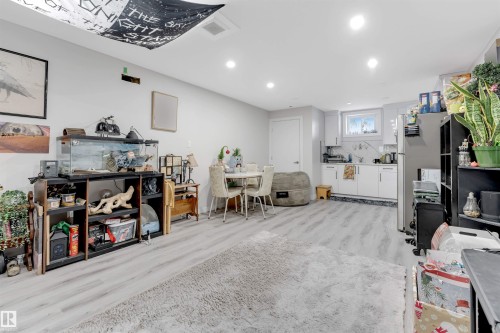 Interior space with white cabinets, light wood finished floors, recessed lighting, and freestanding refrigerator - 12202 45 Street, Edmonton, AB - Indoor