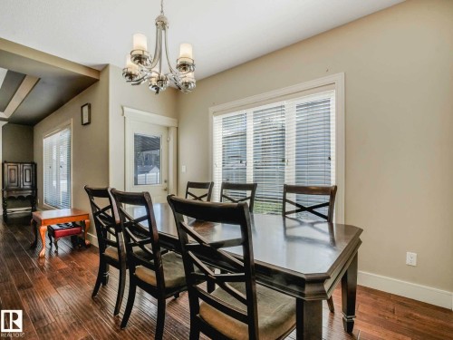 Dining area with wood-finish flooring and a chrome chandelier - 16251 135 Street Nw, Edmonton, AB - Indoor Photo Showing Dining Room