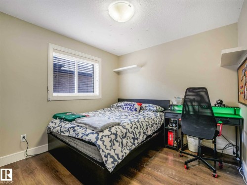 Room featuring wood-finish flooring, a window with blinds, and neutral wall tones - 16251 135 Street Nw, Edmonton, AB - Indoor Photo Showing Bedroom