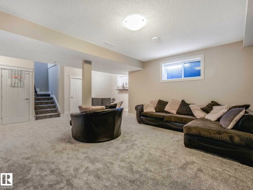 Spacious carpeted room featuring a white ceiling, recessed lighting, and a horizontal window with blinds - 16251 135 Street Nw, Edmonton, AB - Indoor