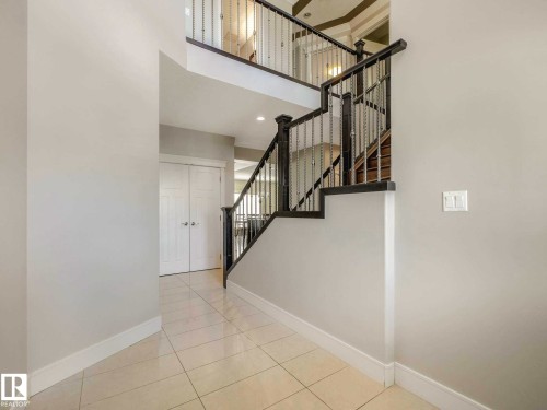 Entryway featuring a grand staircase with dark wood-finish handrails and metal balusters - 16251 135 Street Nw, Edmonton, AB - Indoor Photo Showing Other Room