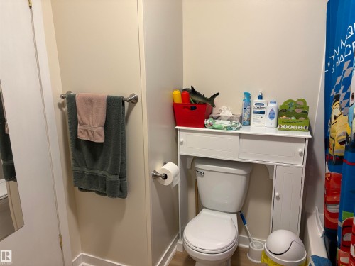 Full bathroom featuring a white toilet, coordinating over-the-toilet storage unit with cabinetry, and a shower/tub combination - 410 Main St, Alcomdale, AB - Indoor Photo Showing Bathroom