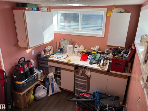 Built-in workbench with white laminate countertop and lower cabinetry - 410 Main St, Alcomdale, AB - Indoor