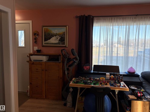 Hardwood-style flooring throughout - 410 Main St, Alcomdale, AB - Indoor Photo Showing Other Room