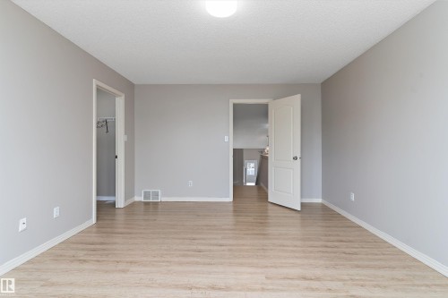 Neutral-toned room featuring wood-finish flooring, light gray walls, a white ceiling, and white trim - 15109 Miller Boulevard, Edmonton, AB - Indoor Photo Showing Other Room