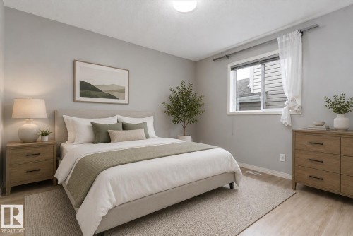 Light-toned wood-finish flooring complements the neutral wall color - 15109 Miller Boulevard, Edmonton, AB - Indoor Photo Showing Bedroom