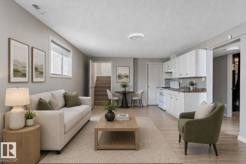 Open-concept living space featuring wood-finish flooring and light gray walls - 15109 Miller Boulevard, Edmonton, AB - Indoor Photo Showing Living Room