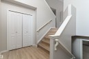 Stairwell featuring wood-finish treads, a white handrail, and light gray wall paint - 15109 Miller Boulevard, Edmonton, AB  - Indoor Photo Showing Other Room 