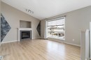 Spacious interior featuring wood-finish flooring and a vaulted ceiling - 15109 Miller Boulevard, Edmonton, AB  - Indoor Photo Showing Living Room With Fireplace 