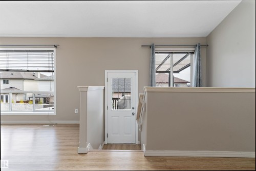 Bright interior featuring light wood-finish flooring, neutral wall tones, and white trim - 15109 Miller Boulevard, Edmonton, AB - Indoor Photo Showing Other Room