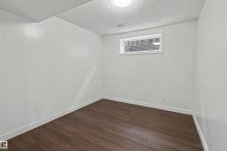 Room featuring wood-finish flooring, white walls, and a single window - 