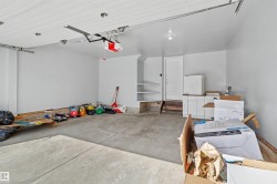 Spacious garage with light gray painted walls, concrete flooring, and an automatic garage door opener - 