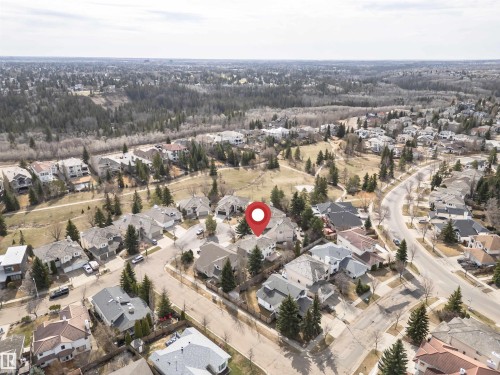 Residential streetscape featuring a detached home with a gray shingle roof and surrounding mature trees - 607 Butterworth Wynd, Edmonton, AB - Outdoor With View