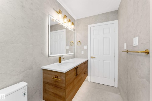 Contemporary bathroom featuring floor-to-ceiling light-toned wall tiling - 607 Butterworth Wynd, Edmonton, AB - Indoor Photo Showing Bathroom