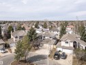 Residential streetscape featuring a collection of multi-story homes with attached garages, mature trees, and varied roofing materials - 607 Butterworth Wynd, Edmonton, AB  - Outdoor 