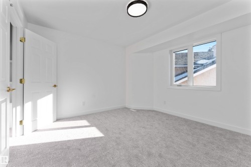 Bright room featuring light gray carpet, white walls, and a contemporary flush-mount ceiling light - 607 Butterworth Wynd, Edmonton, AB - Indoor Photo Showing Other Room