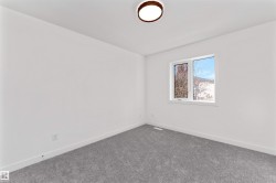 Bright room featuring a large window, gray carpet flooring, white baseboards, and a contemporary ceiling light fixture - 