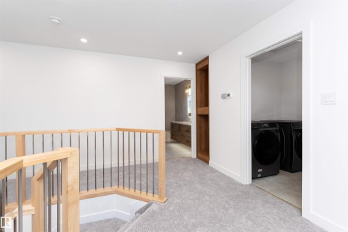 Open landing featuring light wood-finish railing with metal spindles, recessed lighting, and soft grey carpet flooring - 607 Butterworth Wynd, Edmonton, AB - Indoor Photo Showing Other Room