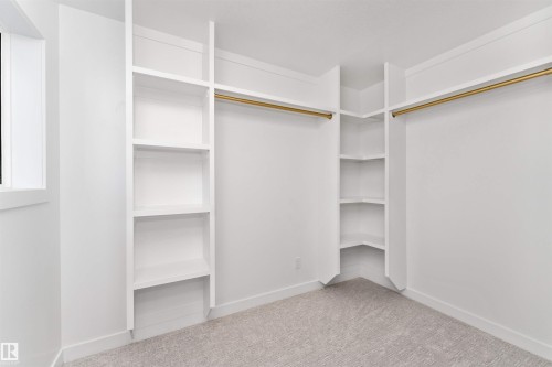 Custom closet system featuring built-in shelving, corner shelving units, and gold-finish hanging rods - 607 Butterworth Wynd, Edmonton, AB - Indoor With Storage