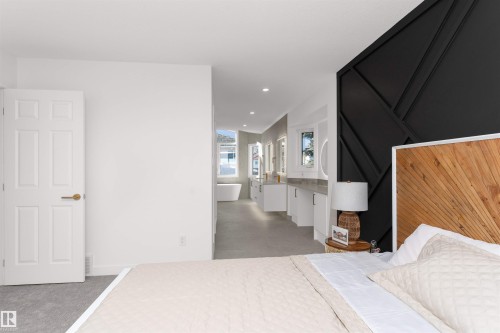 Bedroom with a striking black geometric accent wall and light gray carpeting - 607 Butterworth Wynd, Edmonton, AB - Indoor
