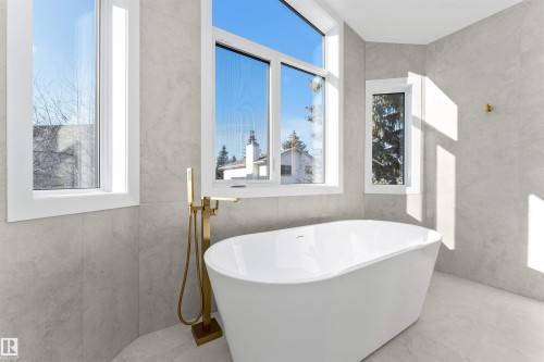 Freestanding soaking tub with a floor-mounted brass faucet - 607 Butterworth Wynd, Edmonton, AB - Indoor Photo Showing Bathroom