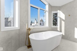Freestanding soaking tub with a floor-mounted brass faucet - 