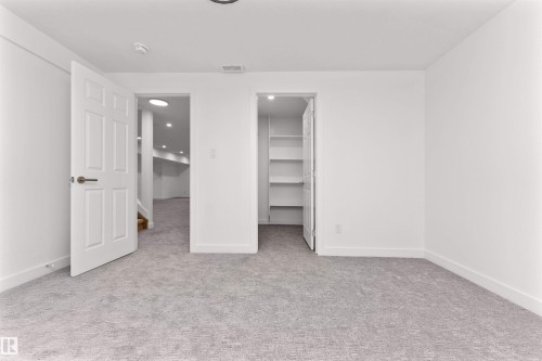 Spacious room featuring light gray carpeting, crisp white walls, and a recessed ceiling light - 607 Butterworth Wynd, Edmonton, AB - Indoor Photo Showing Other Room