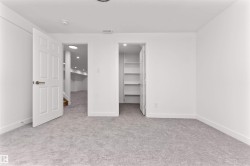 Spacious room featuring light gray carpeting, crisp white walls, and a recessed ceiling light - 