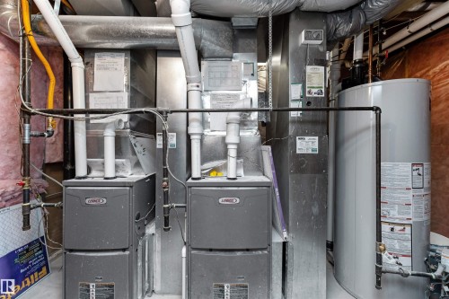 HVAC and water heater utility area featuring two Lennox furnaces, a hot water heater, and extensive ductwork - 607 Butterworth Wynd, Edmonton, AB - Indoor Photo Showing Basement