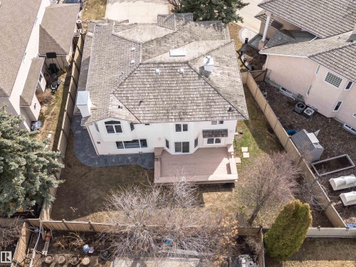 Aerial perspective showcasing a light-colored stucco exterior, a large wood-finish deck, and a multi-level shingle roof - 607 Butterworth Wynd, Edmonton, AB - Outdoor