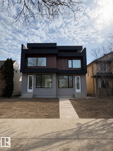Contemporary facade featuring a combination of stucco and wood-finish siding with black trim accents - 9007 92 Street, Edmonton, AB - Outdoor