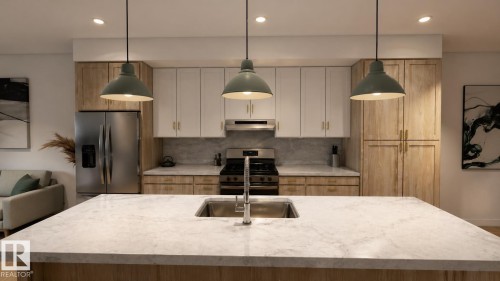 Kitchen featuring an island with an undermount sink, three pendant lights, two-tone cabinetry with gold-finish hardware, and stainless steel appliances - 9007 92 Street, Edmonton, AB - Indoor Photo Showing Kitchen With Stainless Steel Kitchen With Upgraded Kitchen