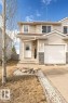 Two-story residence featuring light-colored siding, a white garage door, and a stone-look foundation - 13806 38 Street, Edmonton, AB  - Outdoor 