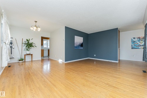 Light-toned walls complement the wood-finish flooring - 11423 50 Avenue, Edmonton, AB - Indoor Photo Showing Bedroom