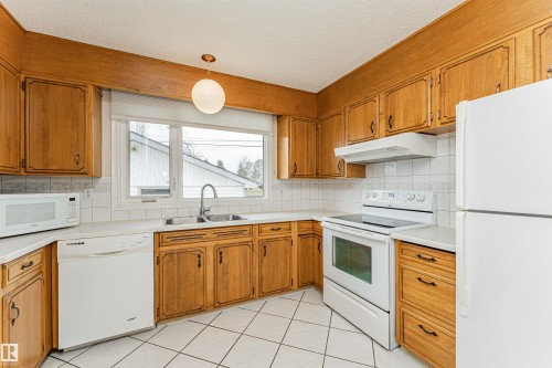 Bright room featuring a large window, light-colored carpeting, and a wood-finish door - 11423 50 Avenue, Edmonton, AB - Indoor Photo Showing Other Room