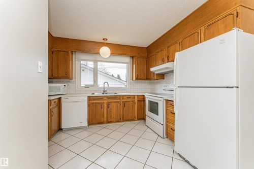 Room featuring light-toned carpeting, white walls, a wood-finish interior door, and a wood-finish bi-fold closet door - 11423 50 Avenue, Edmonton, AB - Indoor