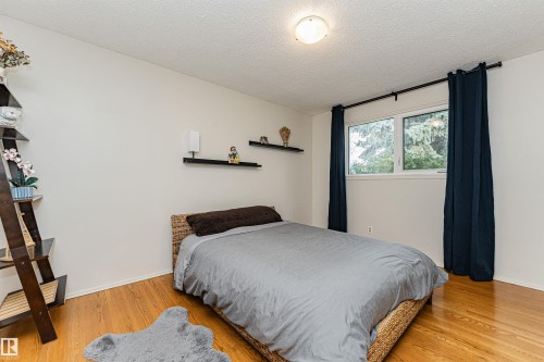 Window with black-out curtains and a metal curtain rod, accompanied by a built-in closet with mirrored sliding doors - 11423 50 Avenue, Edmonton, AB - Indoor Photo Showing Bedroom