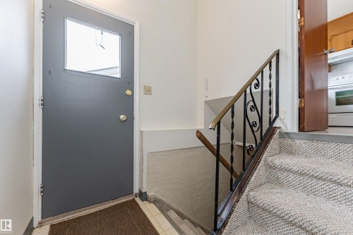 Carpeted room featuring a window with patterned drapes, a flush-mount ceiling light, and a recessed ceiling light - 11423 50 Avenue, Edmonton, AB - Indoor
