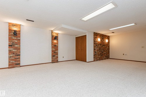 Concrete patio area featuring vinyl siding and a chain-link fence - 11423 50 Avenue, Edmonton, AB - Outdoor With Exterior