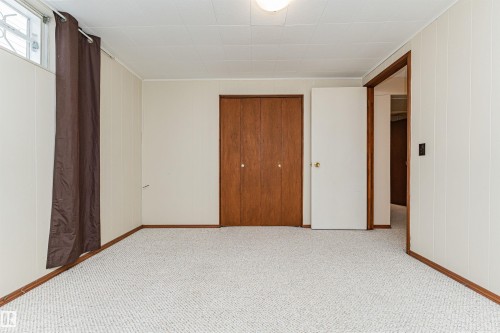 Light-colored carpeting and white paneled walls create a neutral palette - 11423 50 Avenue, Edmonton, AB - Indoor Photo Showing Other Room