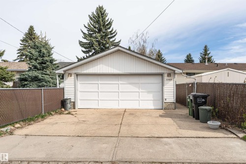 Detached garage featuring white horizontal siding and a white panel garage door - 11423 50 Avenue, Edmonton, AB - Outdoor With Exterior
