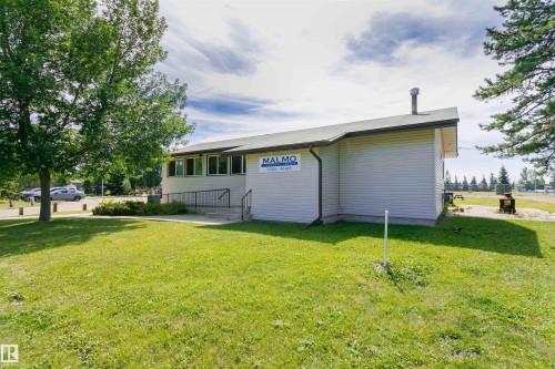 Single-story building featuring light-colored siding, multiple windows, and a sloped roof - 11423 50 Avenue, Edmonton, AB - Outdoor