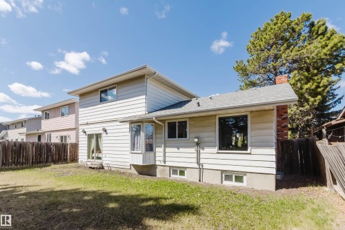 Expansive rear exterior featuring light-colored siding, a bay window, and a sliding glass door - 10423 35 Avenue, Edmonton, AB - Outdoor