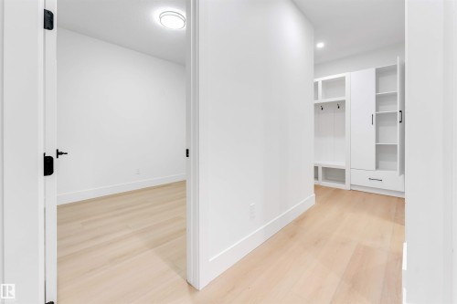 Entryway featuring light-toned flooring, white walls, and built-in storage with shelving and hooks - 4004 35 Street, Beaumont, AB - Indoor Photo Showing Other Room