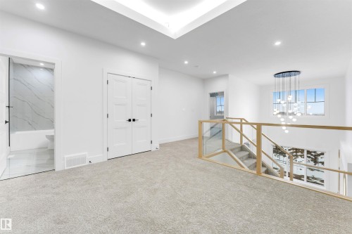 The property features a bright upper-level landing with plush carpeting and recessed lighting - 4004 35 Street, Beaumont, AB - Indoor Photo Showing Other Room