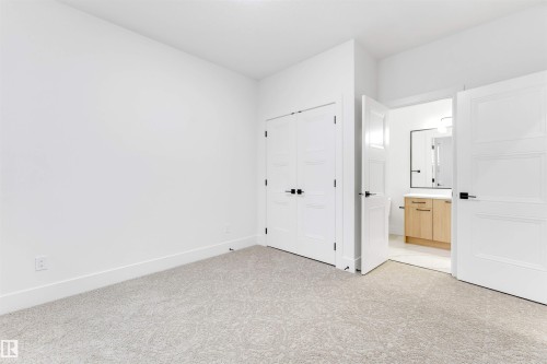 The property features light-colored carpet, white walls, and white trim - 4004 35 Street, Beaumont, AB - Indoor Photo Showing Other Room